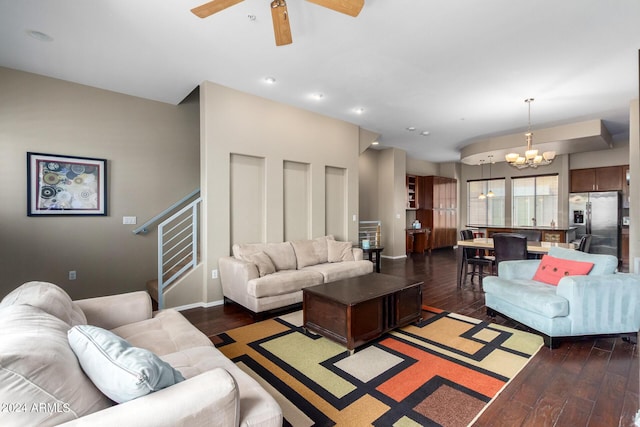 living room with dark hardwood / wood-style flooring and ceiling fan with notable chandelier