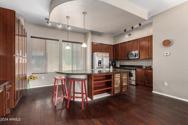 dining space with ceiling fan with notable chandelier, dark hardwood / wood-style floors, and a tiled fireplace