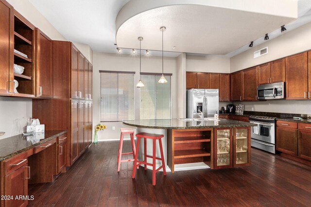 kitchen featuring appliances with stainless steel finishes, a center island with sink, dark hardwood / wood-style floors, and pendant lighting