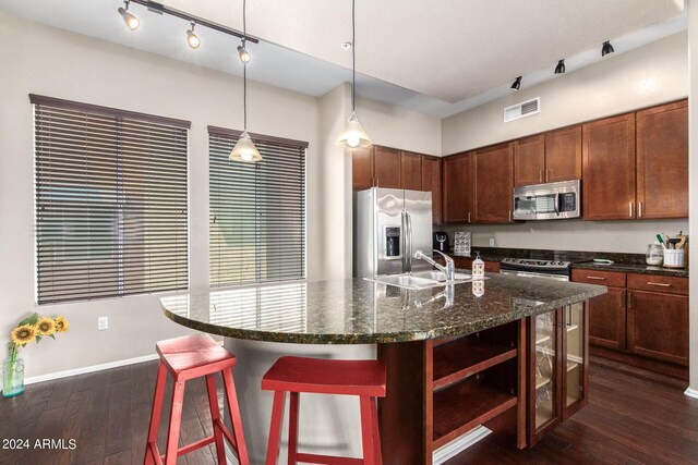 kitchen featuring dark hardwood / wood-style flooring, a center island, stainless steel appliances, and decorative light fixtures