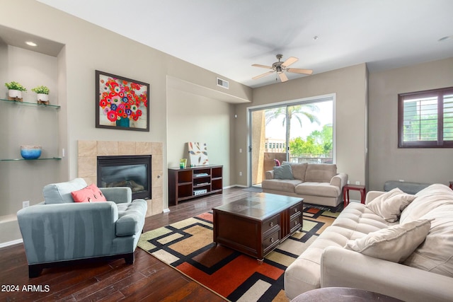 living room featuring hardwood / wood-style flooring, ceiling fan, and a fireplace