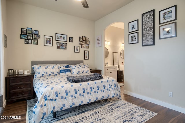 bedroom featuring dark hardwood / wood-style flooring, ensuite bath, and ceiling fan