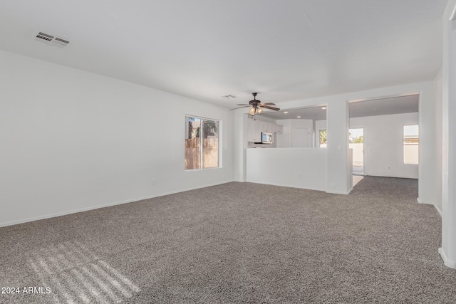 spare room with ceiling fan and carpet