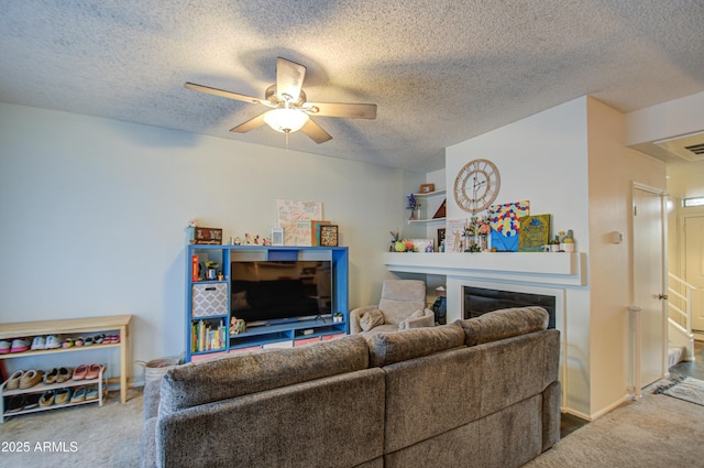 carpeted living room featuring ceiling fan, a fireplace, and a textured ceiling