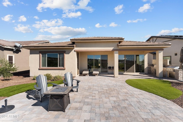 4240 Blacksmith Way, Wickenburg, AZ 85390 - rear view of house with exterior kitchen, a patio, stucco siding, and an outdoor fire pit