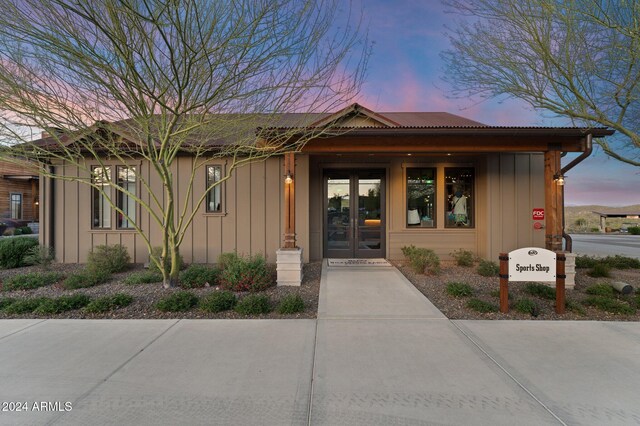 4240 Blacksmith Way, Wickenburg, AZ 85390 - exterior entry at dusk featuring board and batten siding and french doors