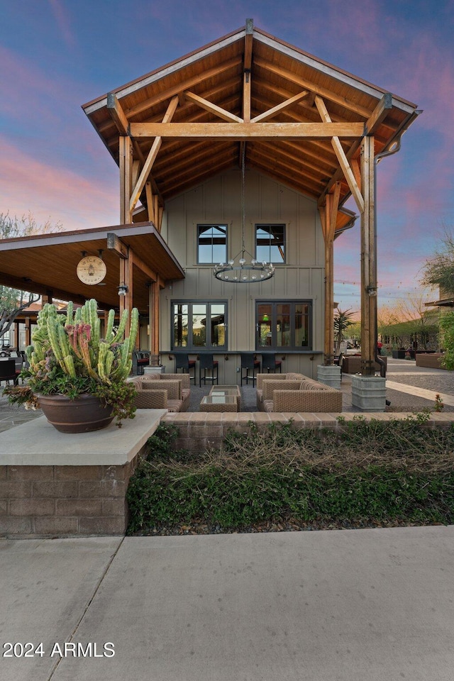 4240 Blacksmith Way, Wickenburg, AZ 85390 - rear view of house with board and batten siding, an outdoor living space, and a patio