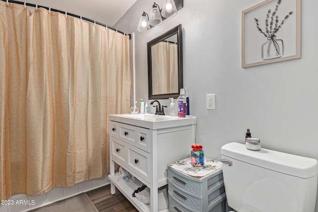 bathroom with hardwood / wood-style floors, toilet, and vanity