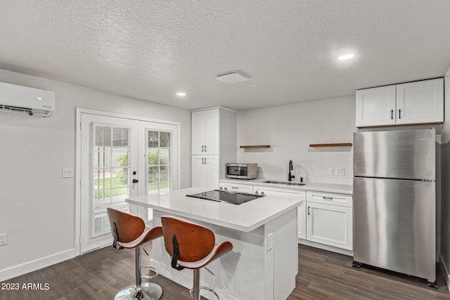 kitchen with french doors, a kitchen island, stainless steel appliances, dark wood-type flooring, and white cabinetry