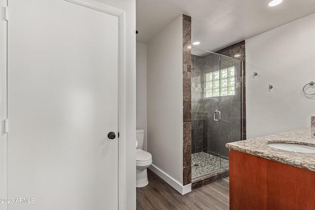 bathroom featuring walk in shower, toilet, vanity, and hardwood / wood-style floors