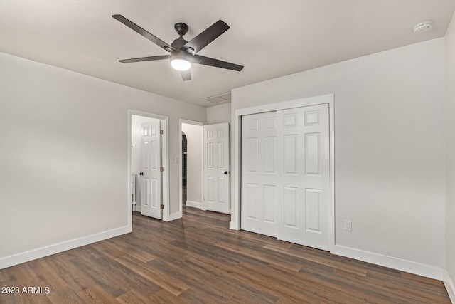 unfurnished bedroom with ceiling fan, a closet, and dark hardwood / wood-style floors