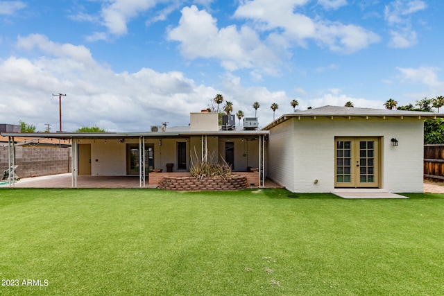 back of house featuring french doors, a lawn, and a patio area