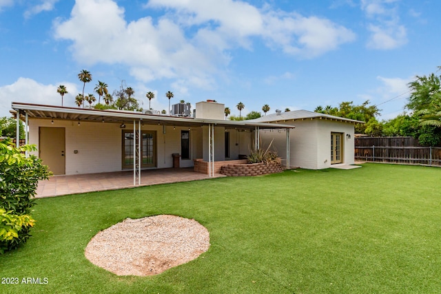 back of property featuring a lawn and a patio