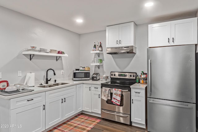 kitchen with wall chimney range hood, white cabinetry, dark hardwood / wood-style floors, and stainless steel appliances