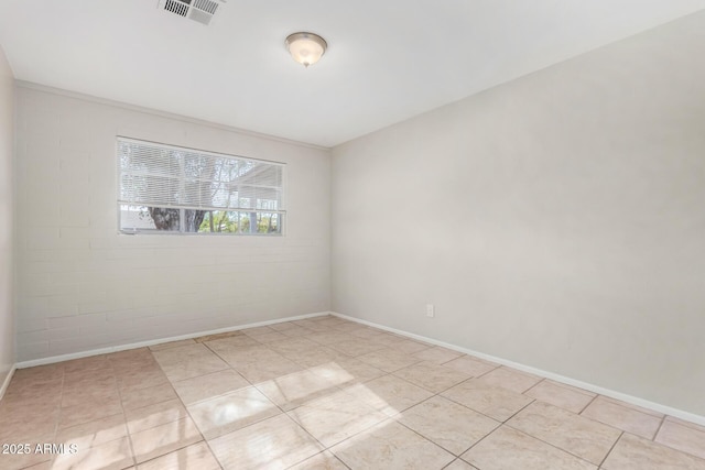 tiled spare room with brick wall