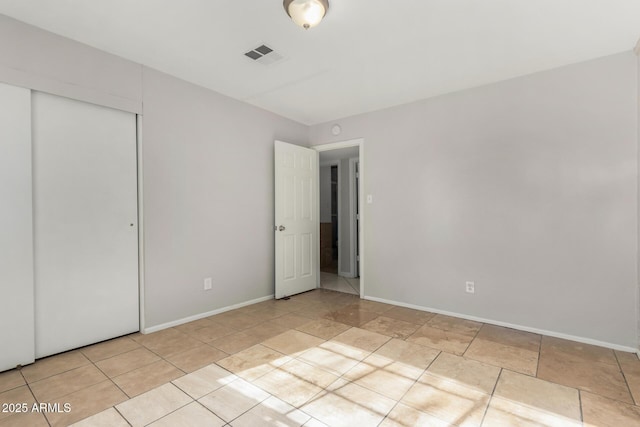 unfurnished bedroom with light tile patterned floors and a closet