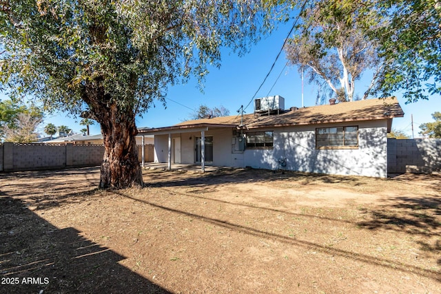 back of property with central AC and a yard