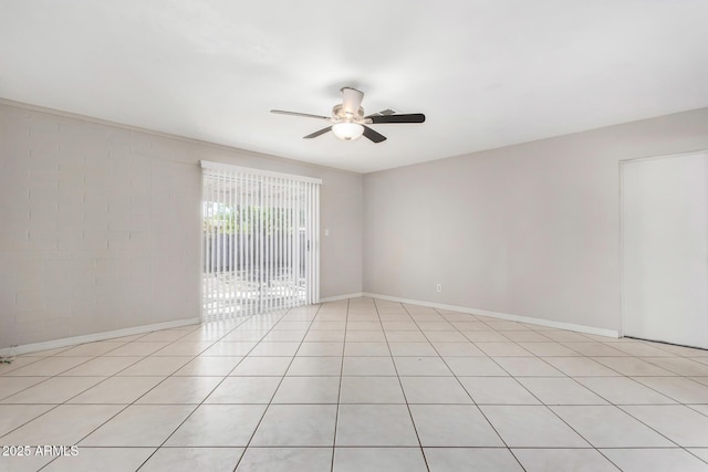 tiled spare room with ceiling fan and brick wall