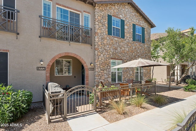 4772 E Portola Valley Dr Unit 102, Gilbert, AZ 85297 - view of front of house featuring stone siding, a gate, and stucco siding