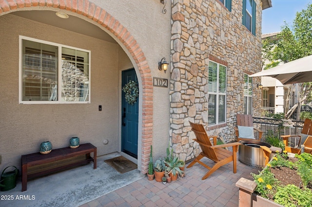 4772 E Portola Valley Dr Unit 102, Gilbert, AZ 85297 - doorway to property with stone siding, stucco siding, and a patio