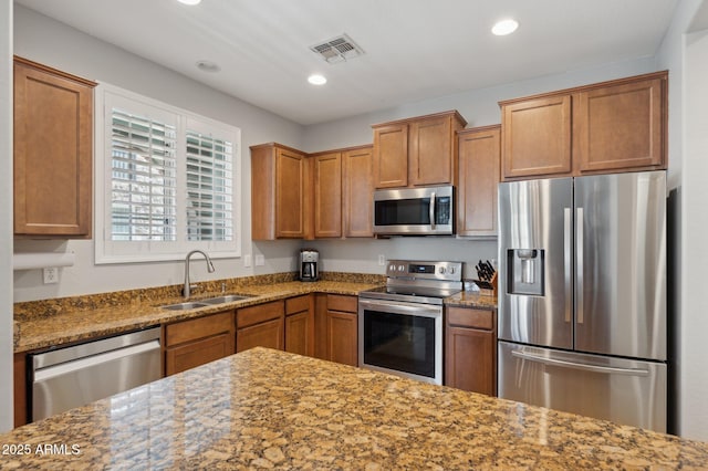 4772 E Portola Valley Dr Unit 102, Gilbert, AZ 85297 - kitchen with stainless steel appliances, a sink, brown cabinetry, and recessed lighting
