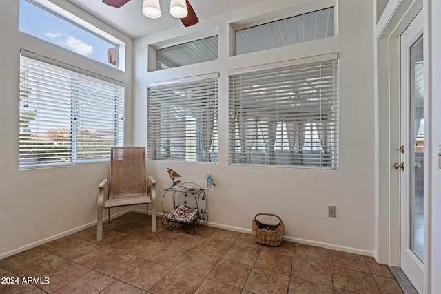 unfurnished room with ceiling fan, a healthy amount of sunlight, and tile patterned flooring