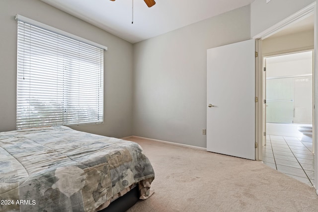 bedroom featuring light carpet, connected bathroom, and ceiling fan