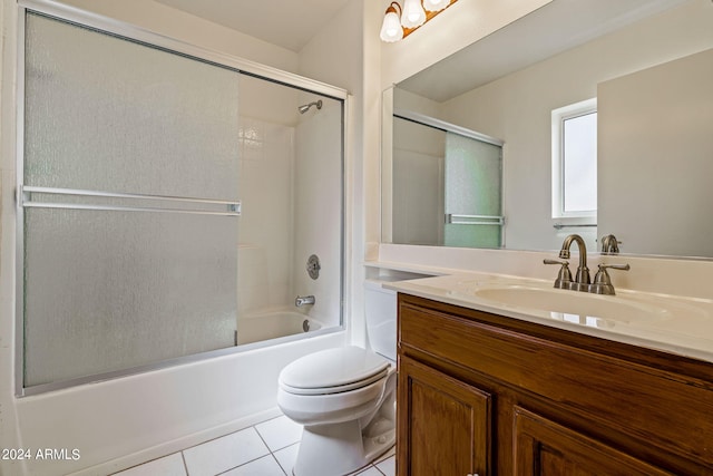 full bathroom featuring vanity, shower / bath combination with glass door, toilet, and tile patterned flooring