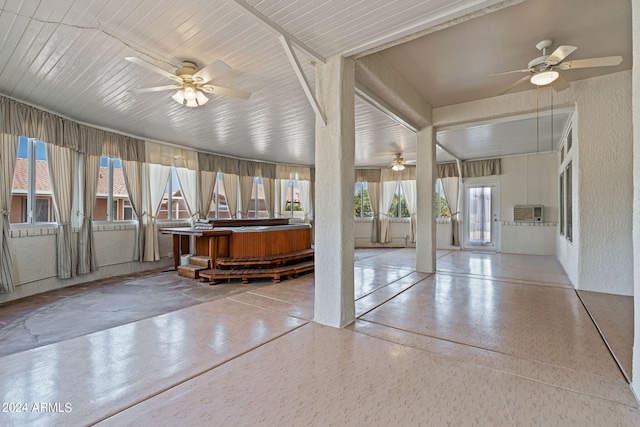 unfurnished sunroom with wood ceiling, a healthy amount of sunlight, and ceiling fan