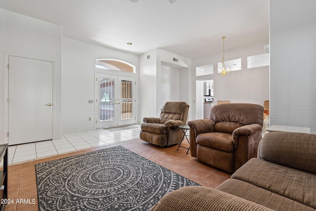 living room with french doors, light tile patterned flooring, and a chandelier