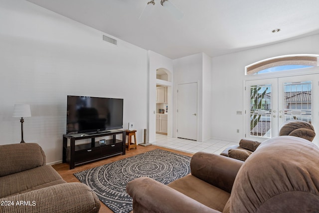 living room featuring french doors, ceiling fan, light hardwood / wood-style floors, and built in shelves