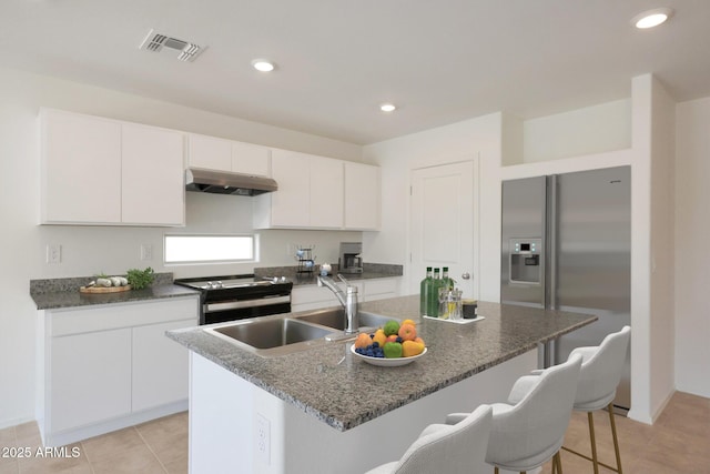 1431 W Tigua Way, Coolidge, AZ 85128 - kitchen featuring under cabinet range hood, electric range oven, a breakfast bar area, stainless steel fridge with ice dispenser, and white cabinets