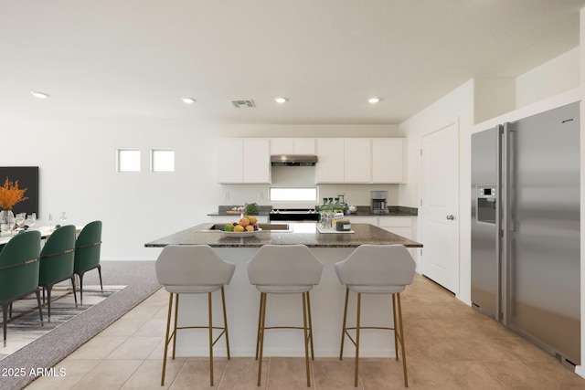 1431 W Tigua Way, Coolidge, AZ 85128 - kitchen featuring high quality fridge, under cabinet range hood, a kitchen bar, a kitchen island, and recessed lighting
