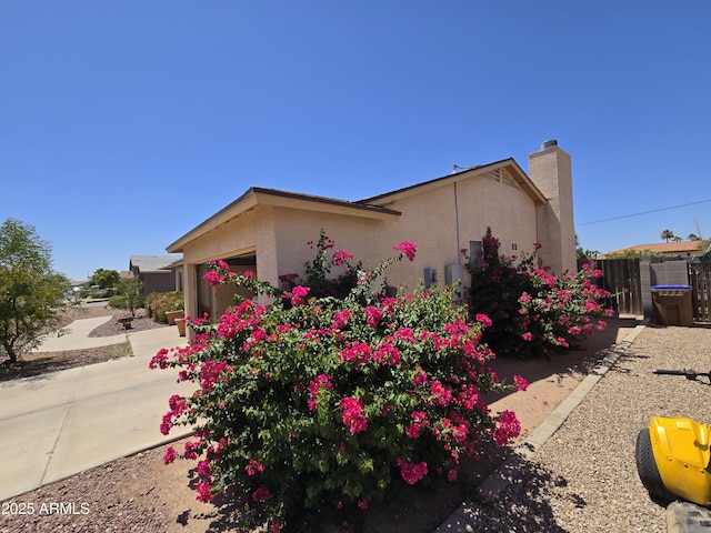 804 W Hess Ave, Coolidge, AZ 85128 - view of property exterior with an attached garage, stucco siding, driveway, and a chimney