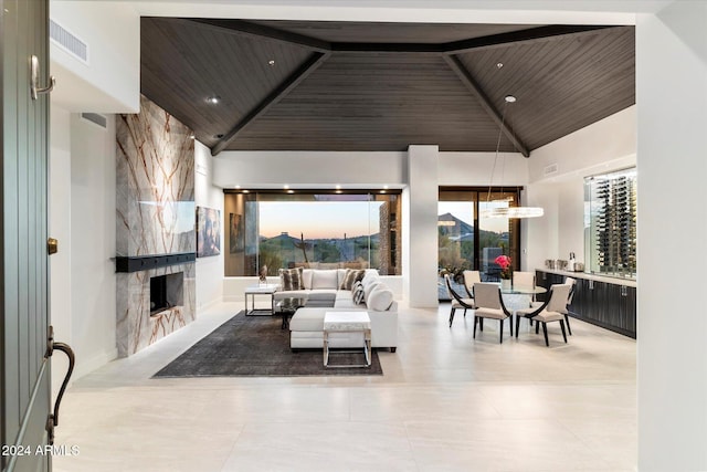 living room with a fireplace, high vaulted ceiling, beamed ceiling, and wood ceiling