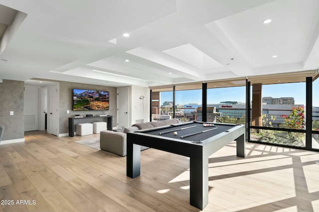 rec room featuring expansive windows, a tray ceiling, billiards, and light hardwood / wood-style flooring