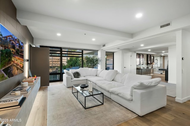 living area with visible vents, recessed lighting, baseboards, and light wood-style floors