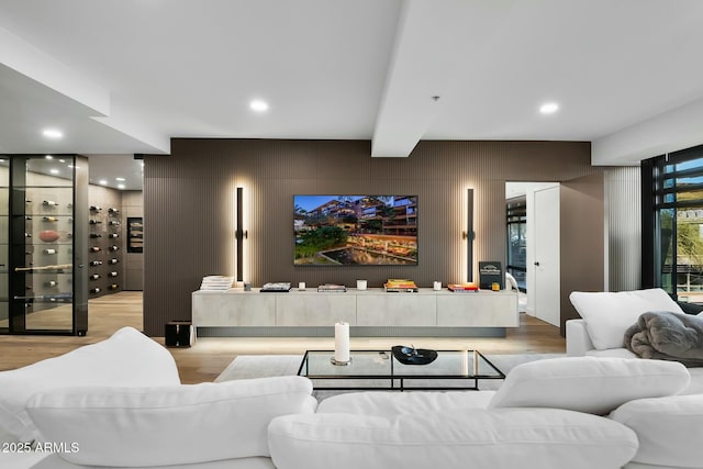 living area with beam ceiling, recessed lighting, and wood finished floors