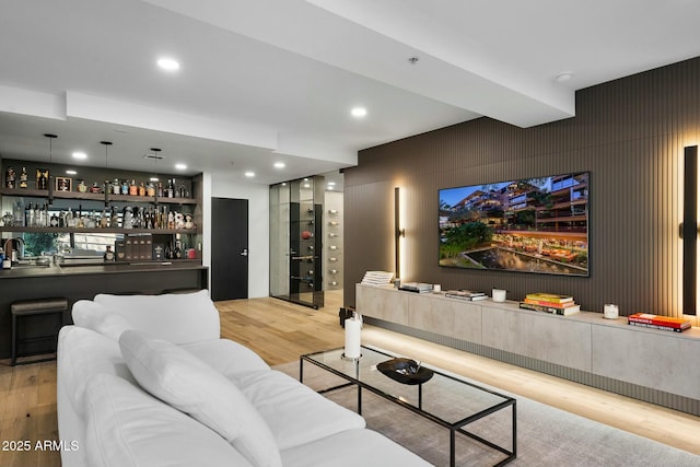 living room featuring recessed lighting, indoor wet bar, and wood finished floors