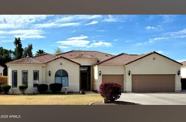mediterranean / spanish-style home with a front yard, driveway, stucco siding, a garage, and a tile roof