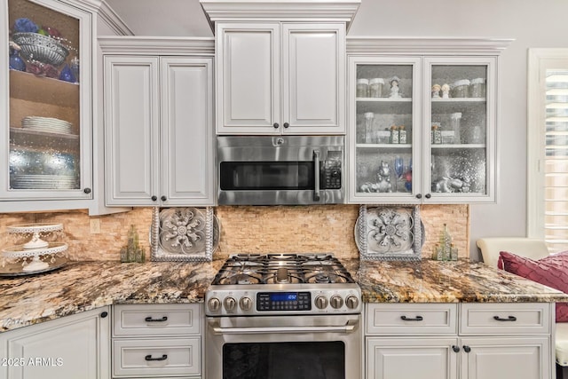 kitchen with backsplash, stainless steel appliances, and glass insert cabinets
