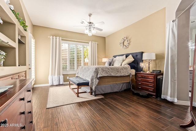 bedroom featuring dark wood finished floors, a ceiling fan, and baseboards