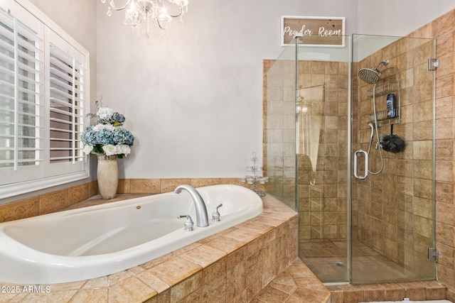 bathroom with a garden tub, a stall shower, and a chandelier
