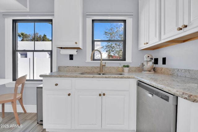 kitchen with white cabinetry, sink, stainless steel dishwasher, and a wealth of natural light