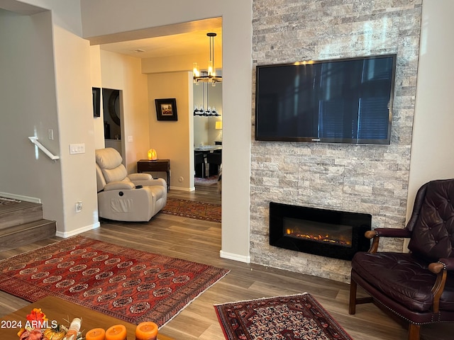 living room featuring hardwood / wood-style floors, a fireplace, and a notable chandelier