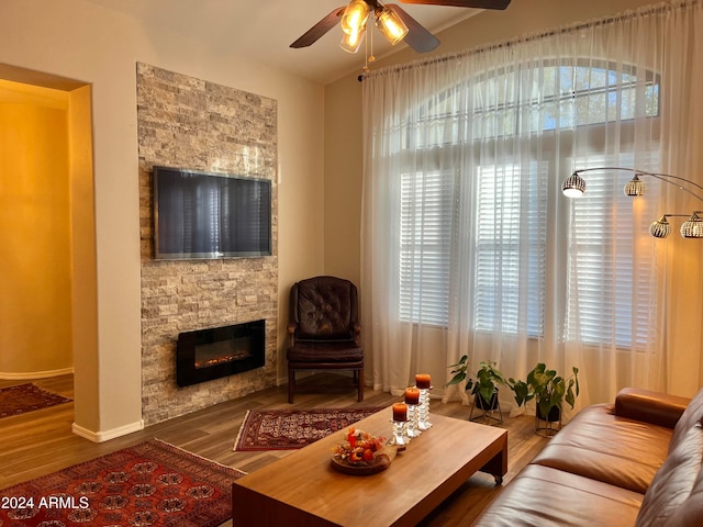 living room featuring a fireplace, wood-type flooring, and ceiling fan