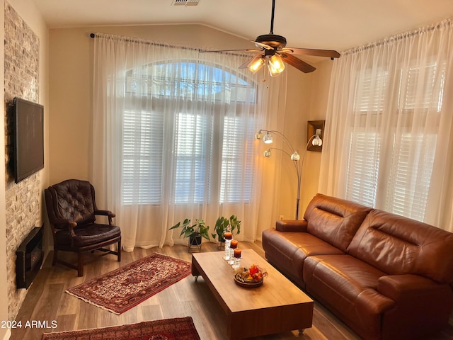 living room with ceiling fan, light hardwood / wood-style flooring, and vaulted ceiling