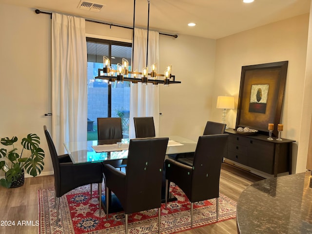 dining space featuring light hardwood / wood-style floors and an inviting chandelier