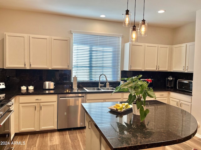 kitchen with backsplash, appliances with stainless steel finishes, sink, and white cabinets