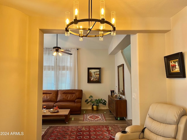 living room with wood-type flooring and ceiling fan with notable chandelier